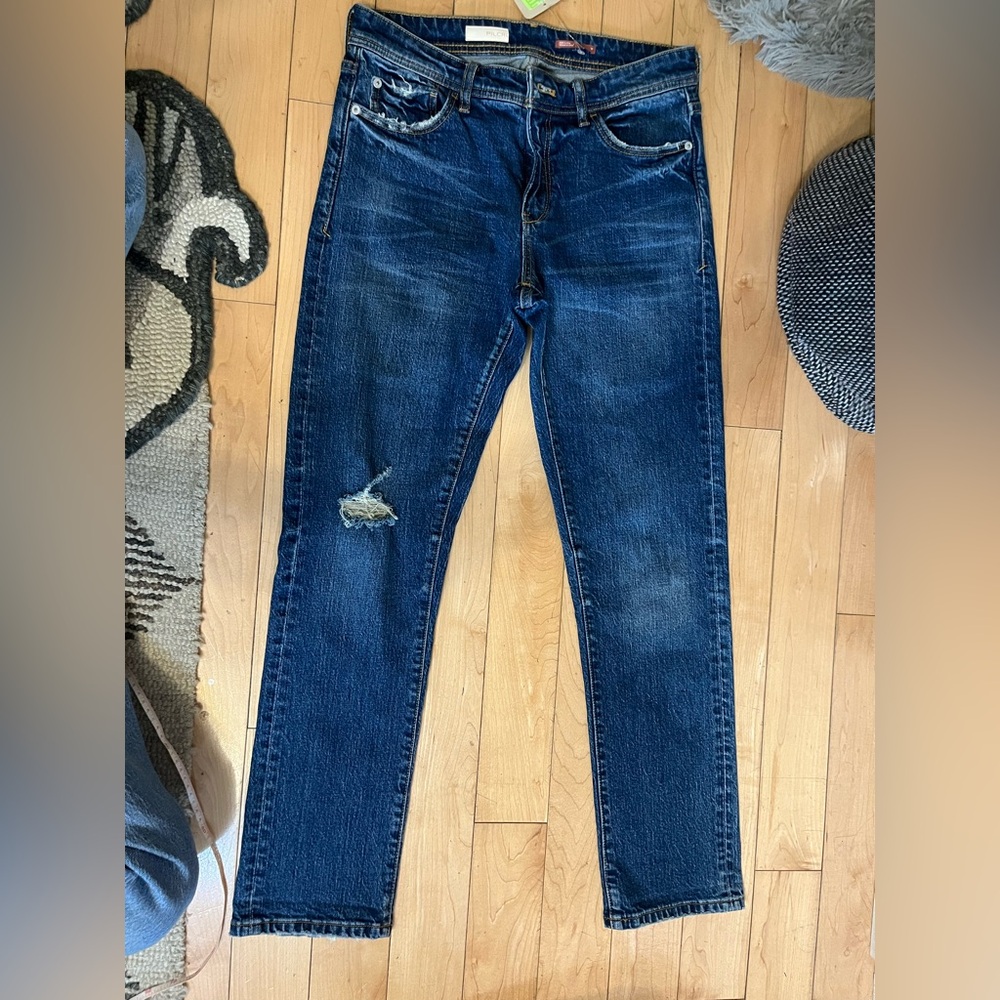 Pilcro, size 27 stretch medium dark blue jeans with ripped knee detail.